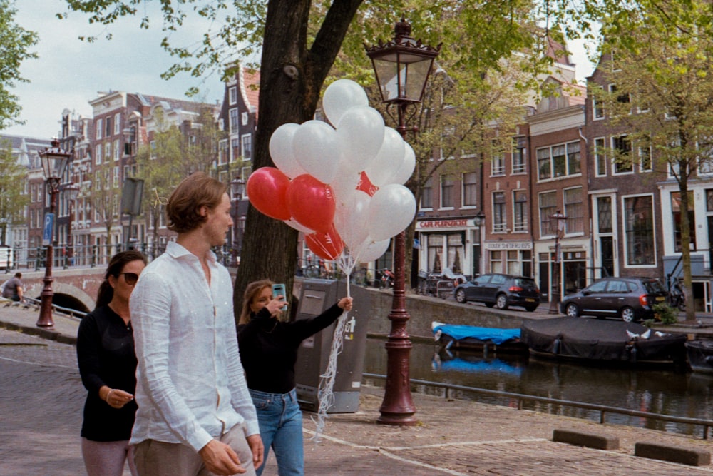 woman in black shirt holding pink balloons