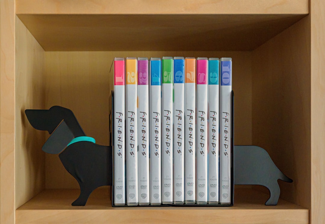white and purple books on brown wooden shelf