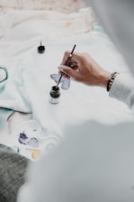 person holding pen and writing on paper