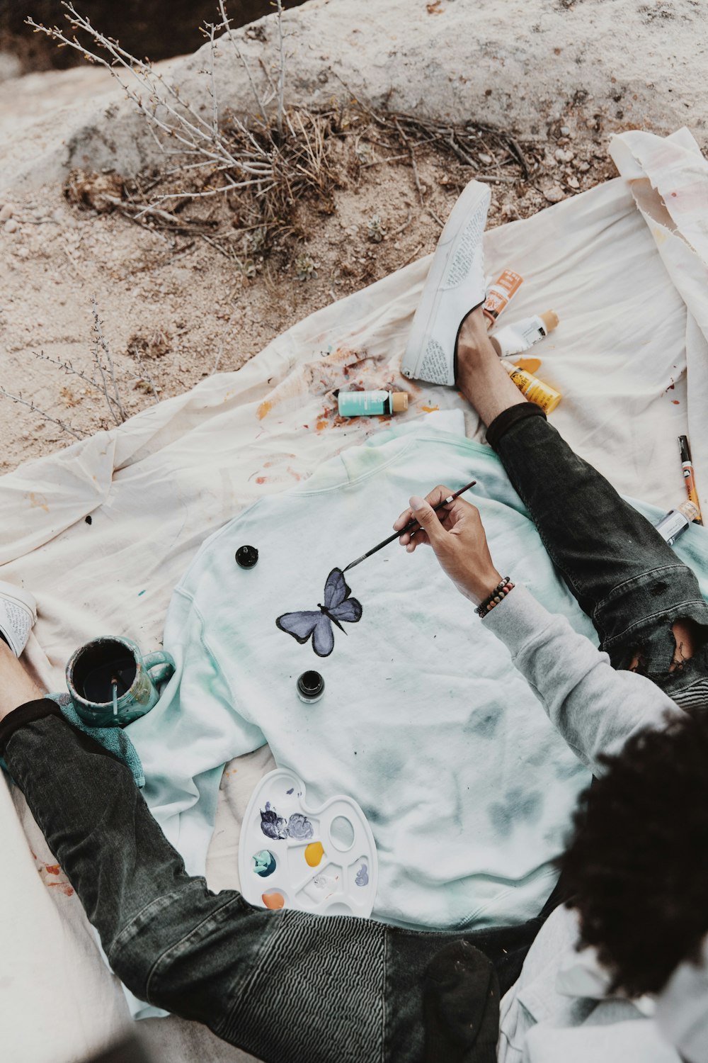 person in gray long sleeve shirt holding paint brush