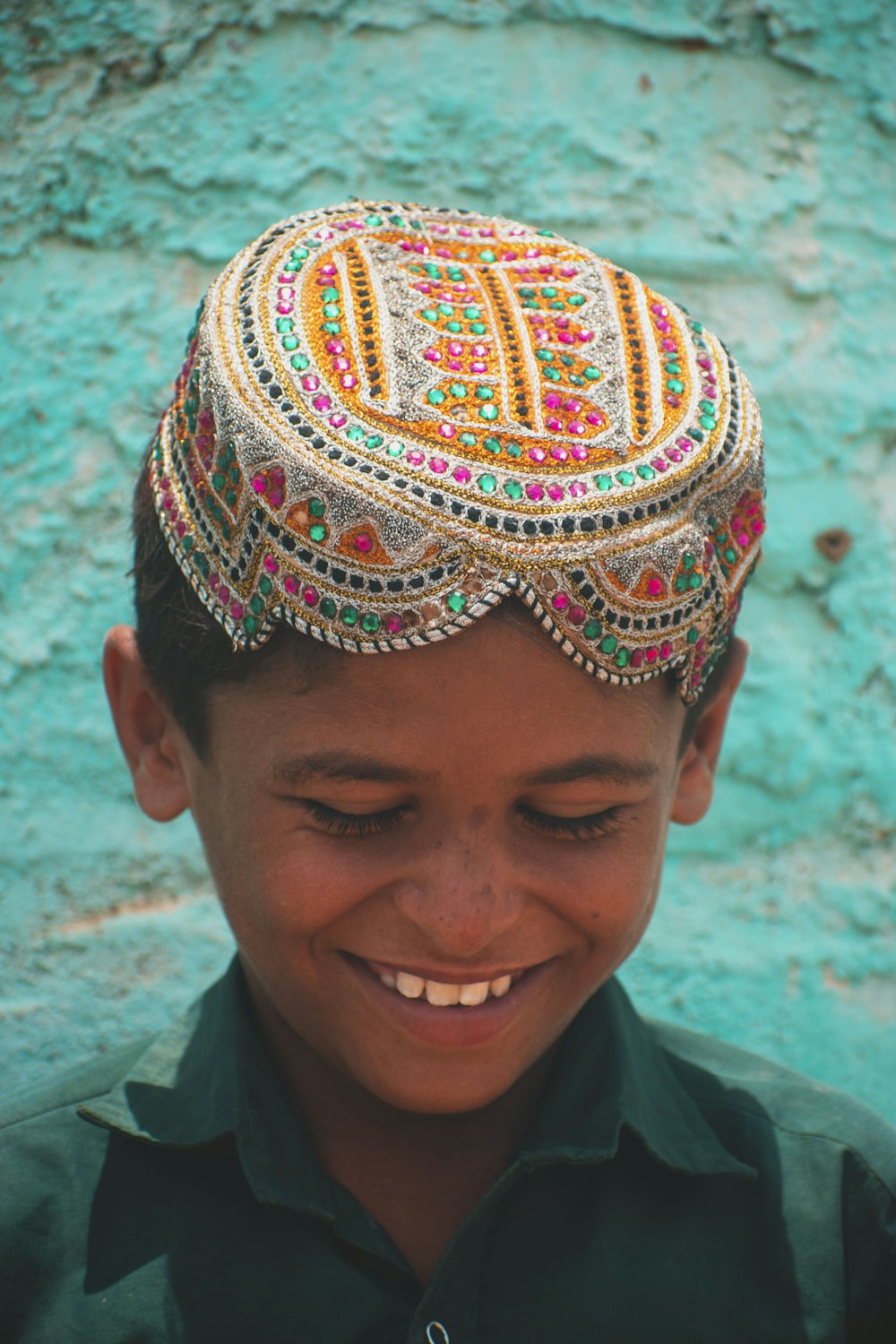 a young boy wearing a colorful head piece
