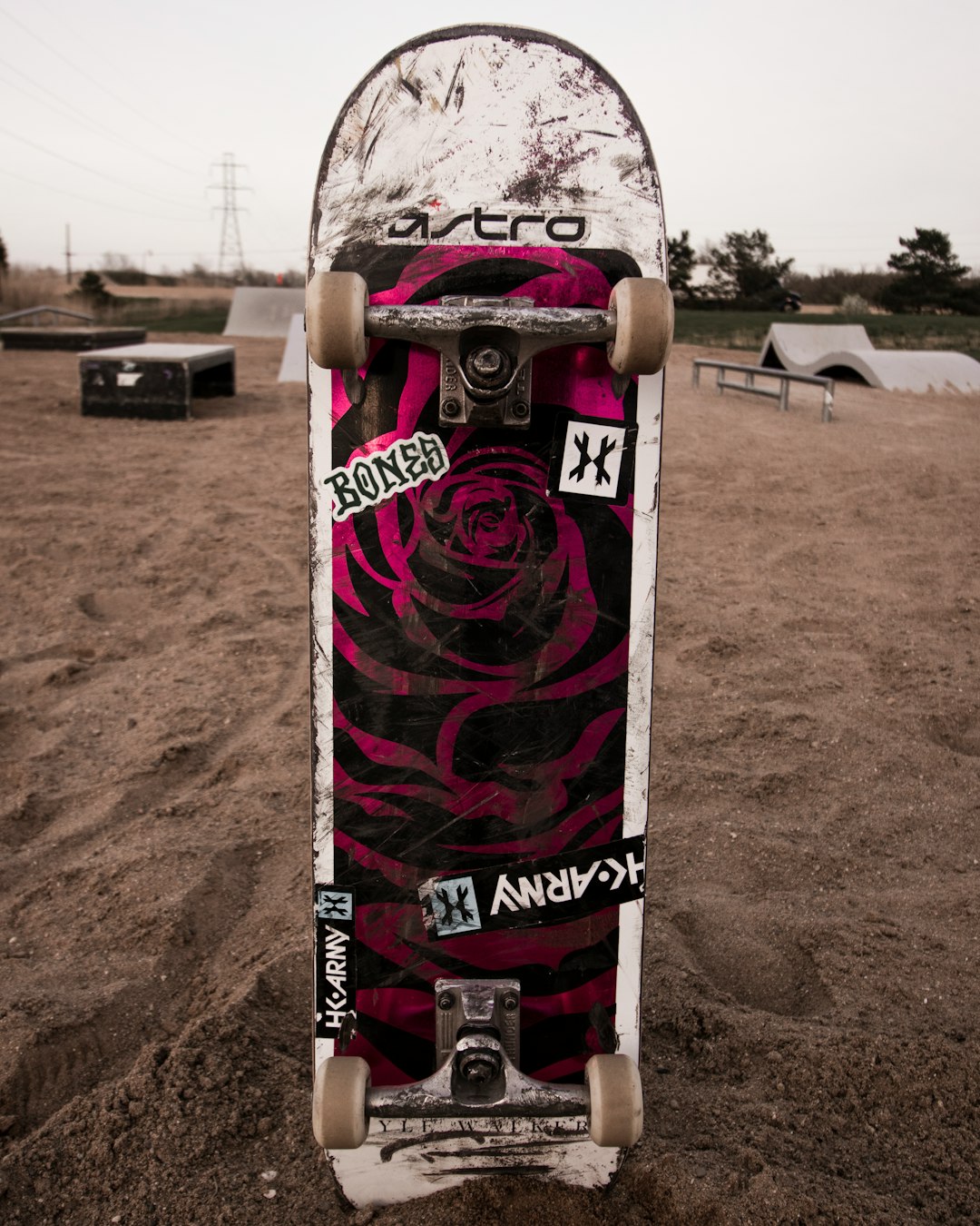 white black and red skateboard on brown sand during daytime