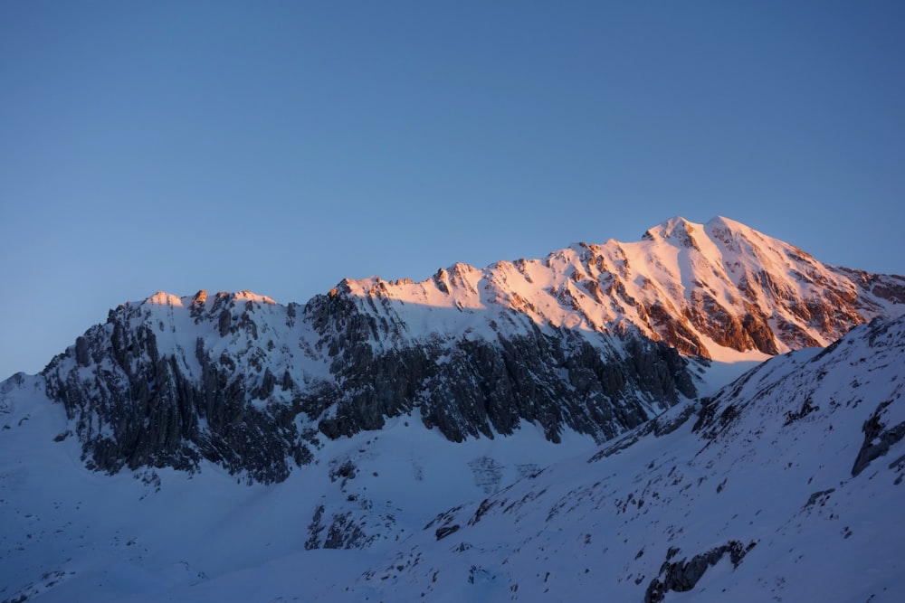 montagne enneigée sous ciel bleu pendant la journée