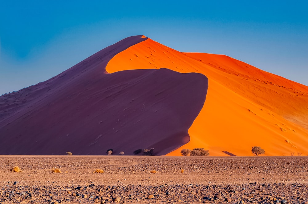 dune di sabbia marrone sotto il cielo blu durante il giorno