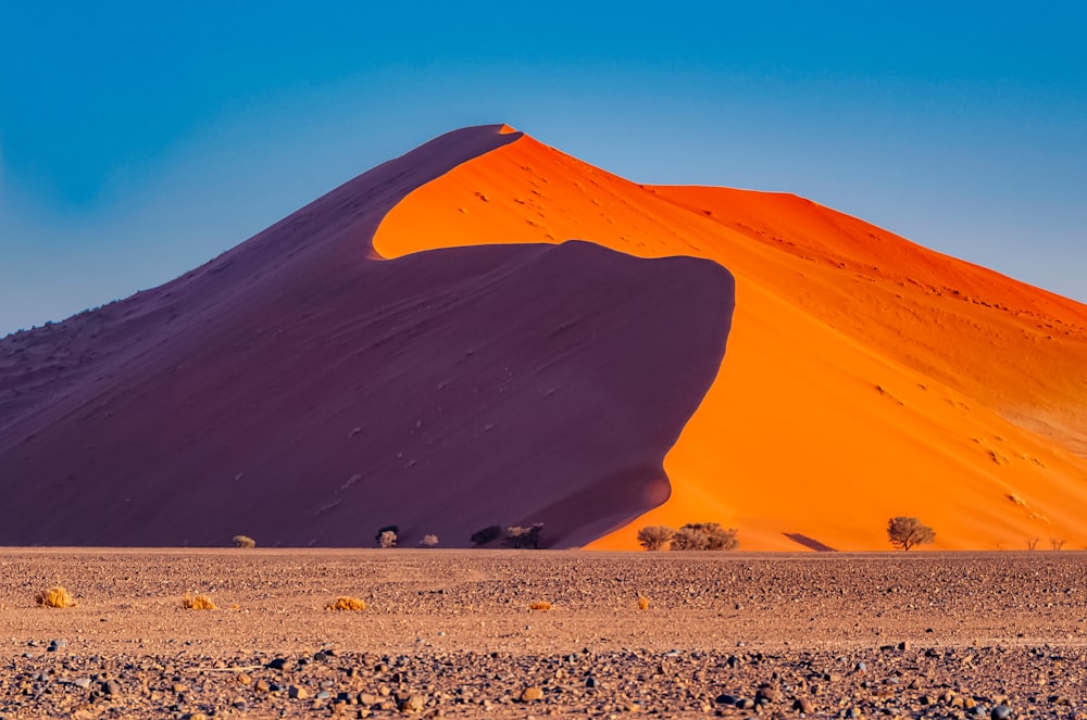 brown sand dunes under blue sky during daytime