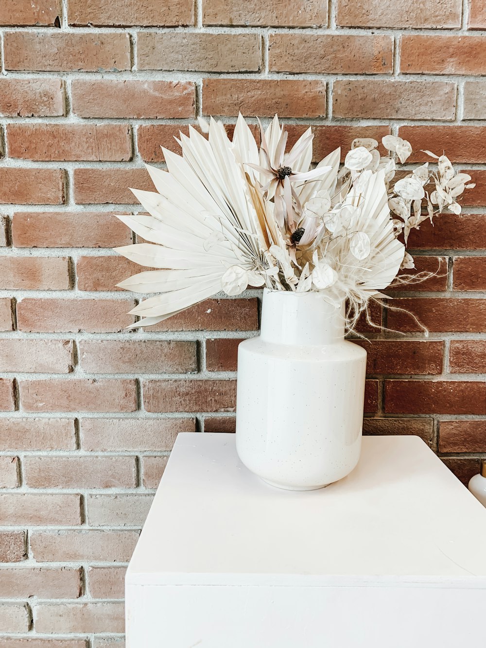 white flower in white ceramic vase