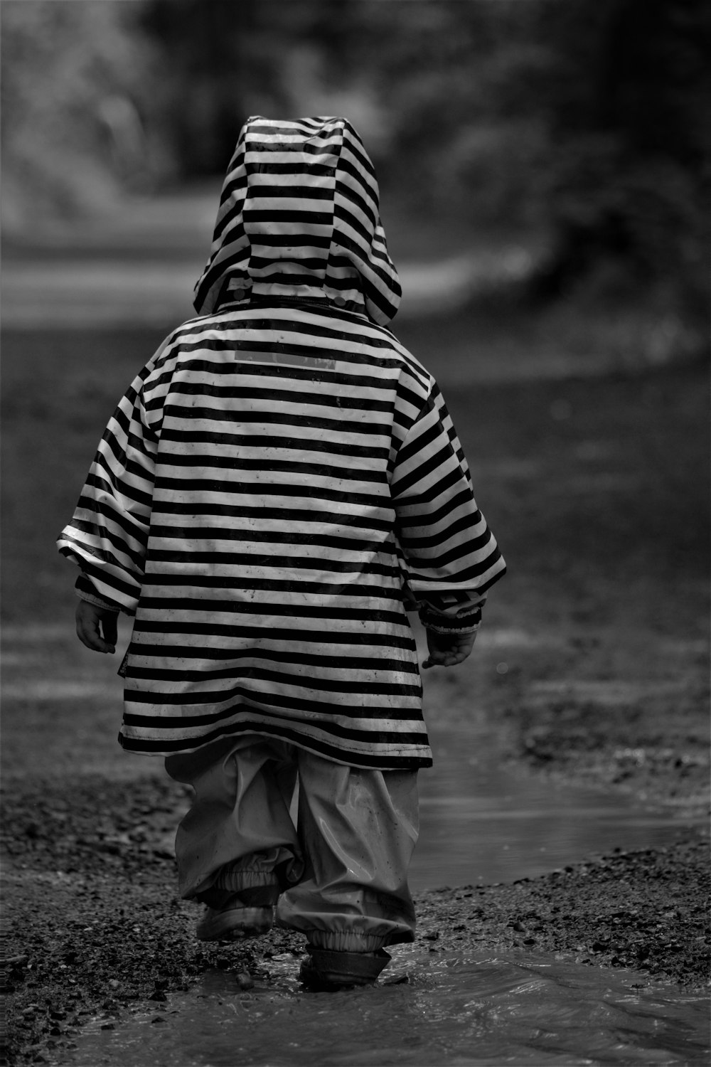 grayscale photo of person in striped shirt and pants