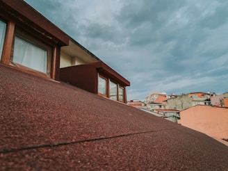 A freshly installed sloped roof on a brownstone building in East Village under a clear blue sky