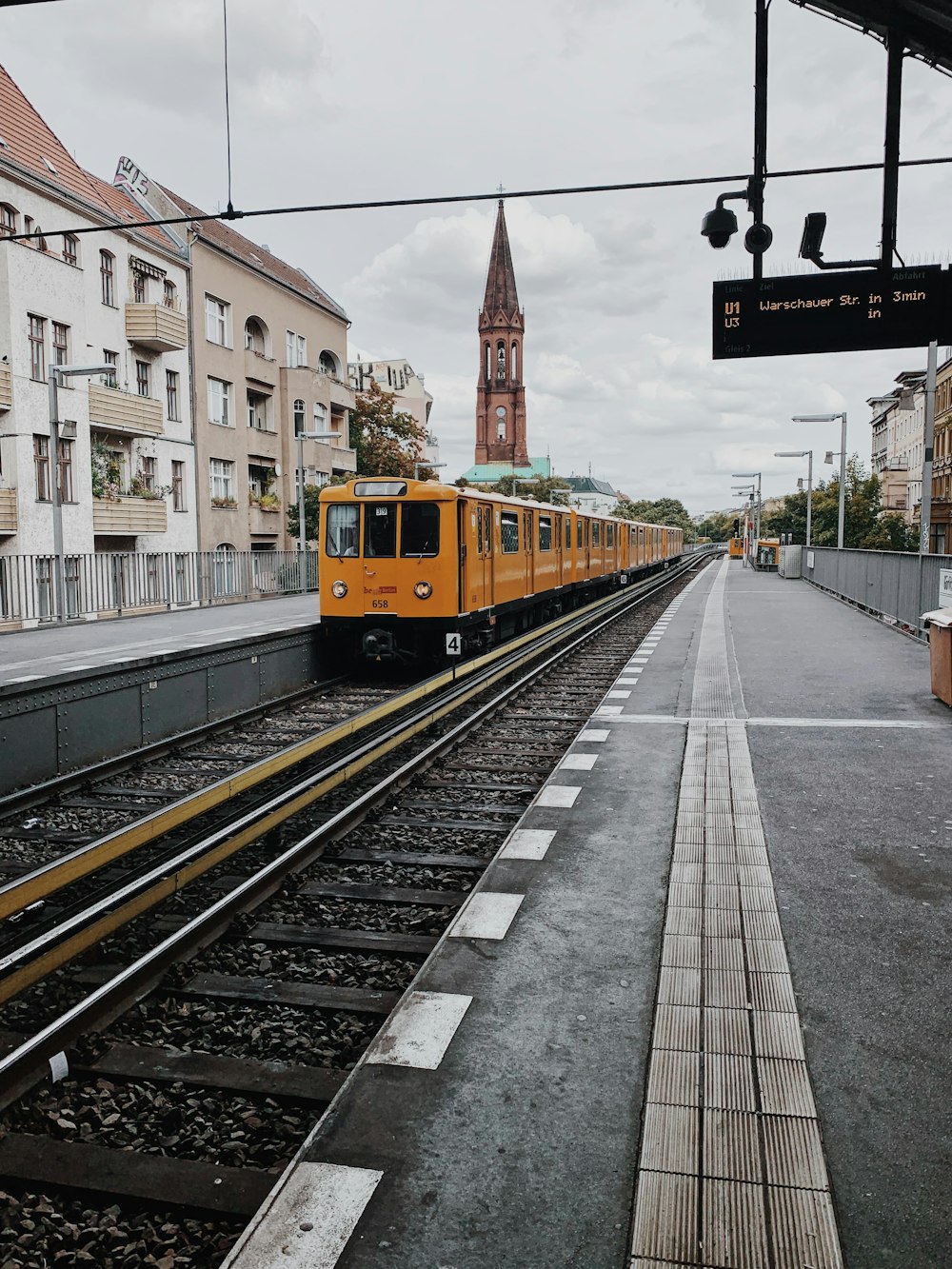 gelber und schwarzer Zug tagsüber auf der Bahnstrecke