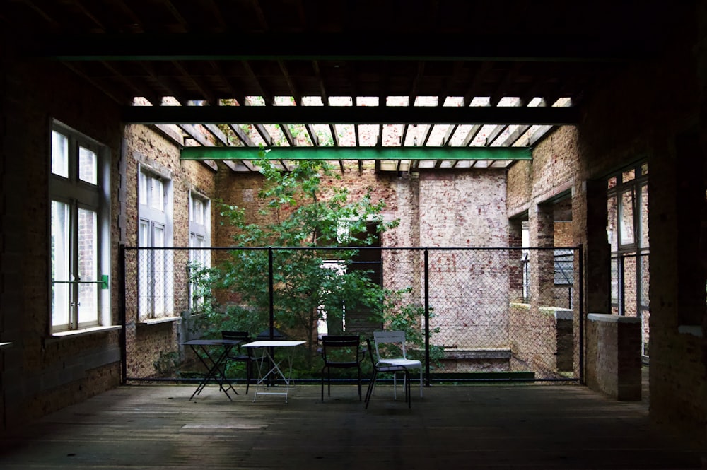 black metal chairs and table near brick wall