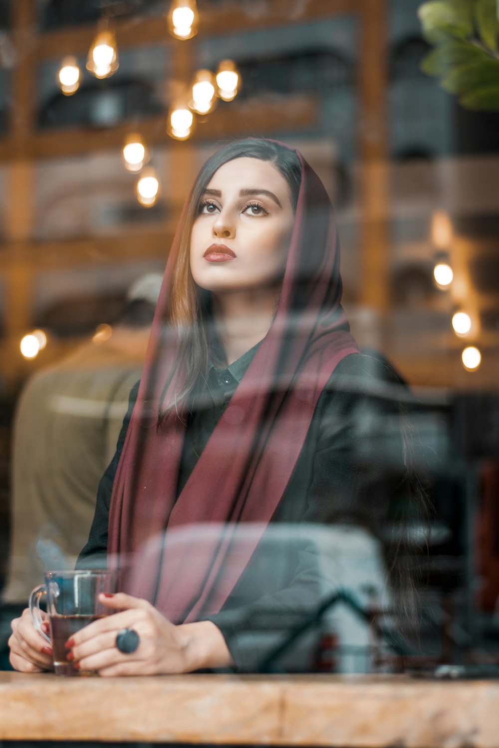 woman in black hijab holding clear drinking glass