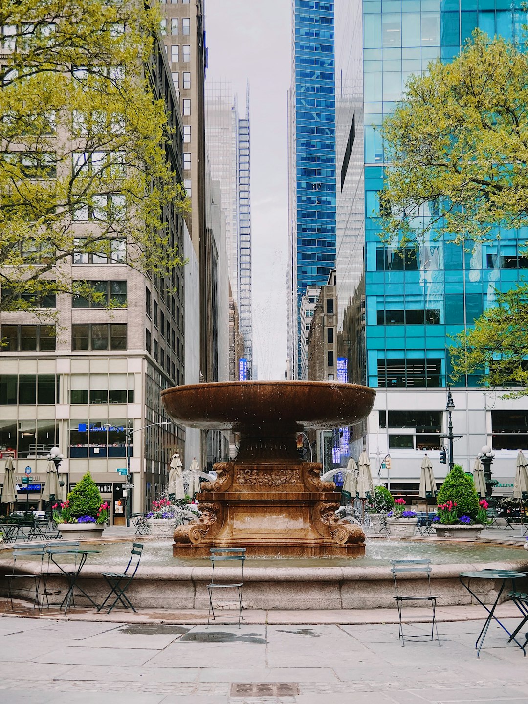 brown concrete fountain in the middle of the city during daytime