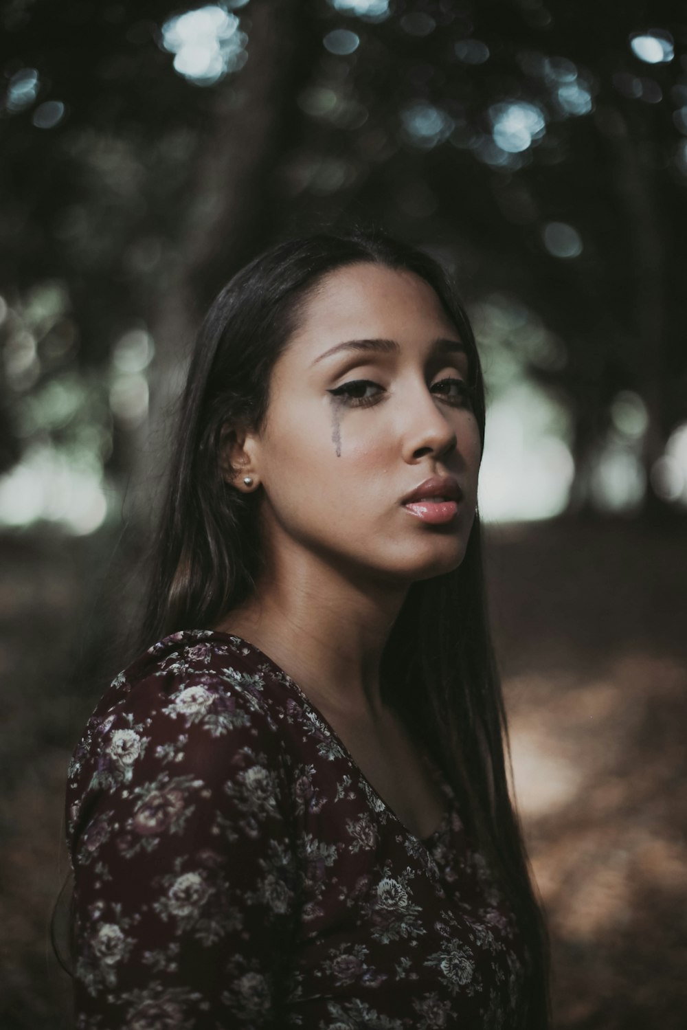 mulher na camisa floral preta e vermelha