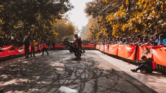 man in black jacket riding motorcycle on road during daytime in Banaras Hindu University India