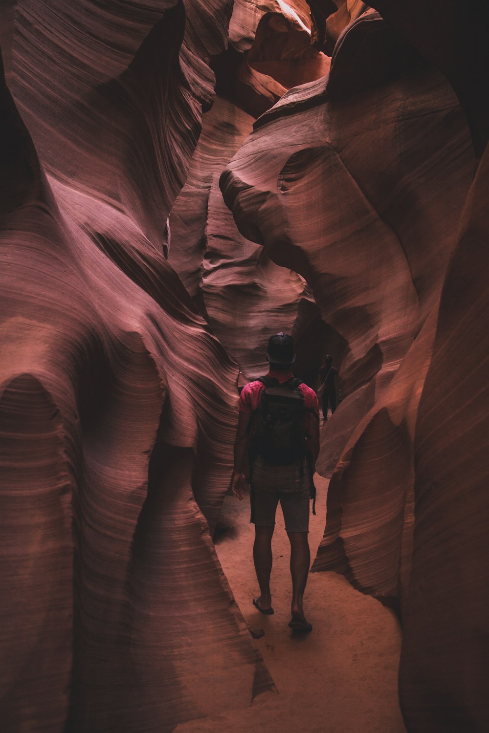 2 women in black jacket and black pants standing in brown rock formation during daytime