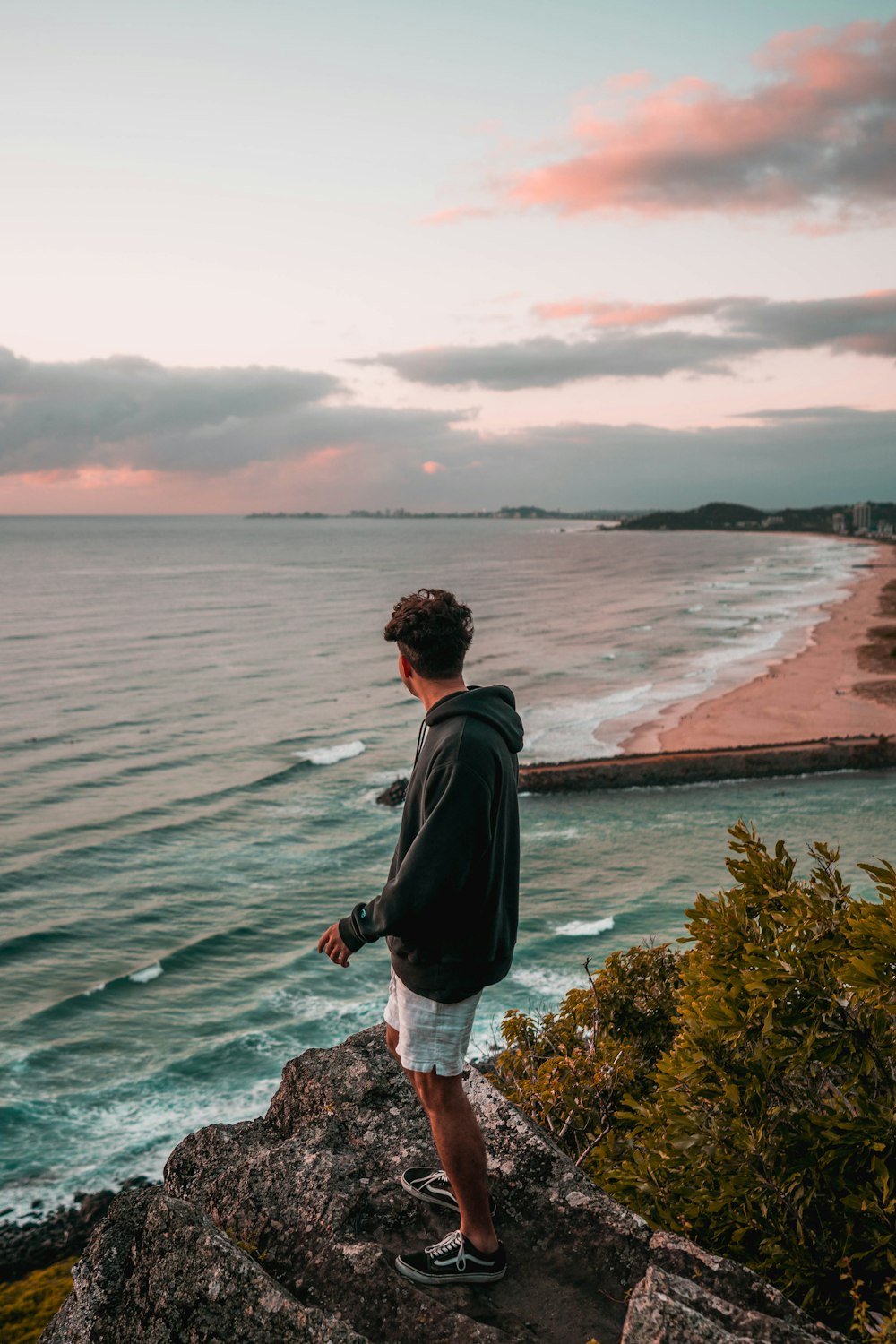 a man standing on top of a cliff near the ocean