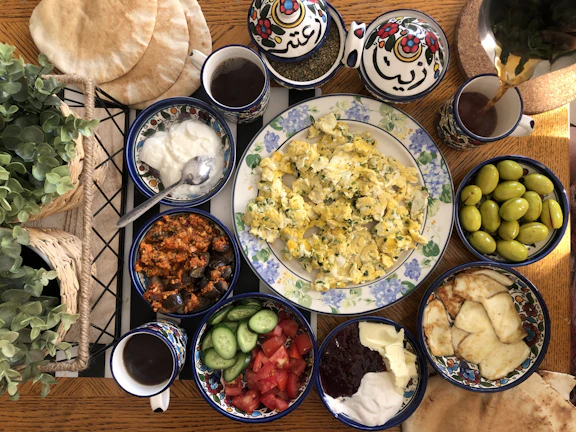 Close-up of a traditional Egyptian breakfast plate with ful medames and fresh pita bread on a white and blue tablecloth.
