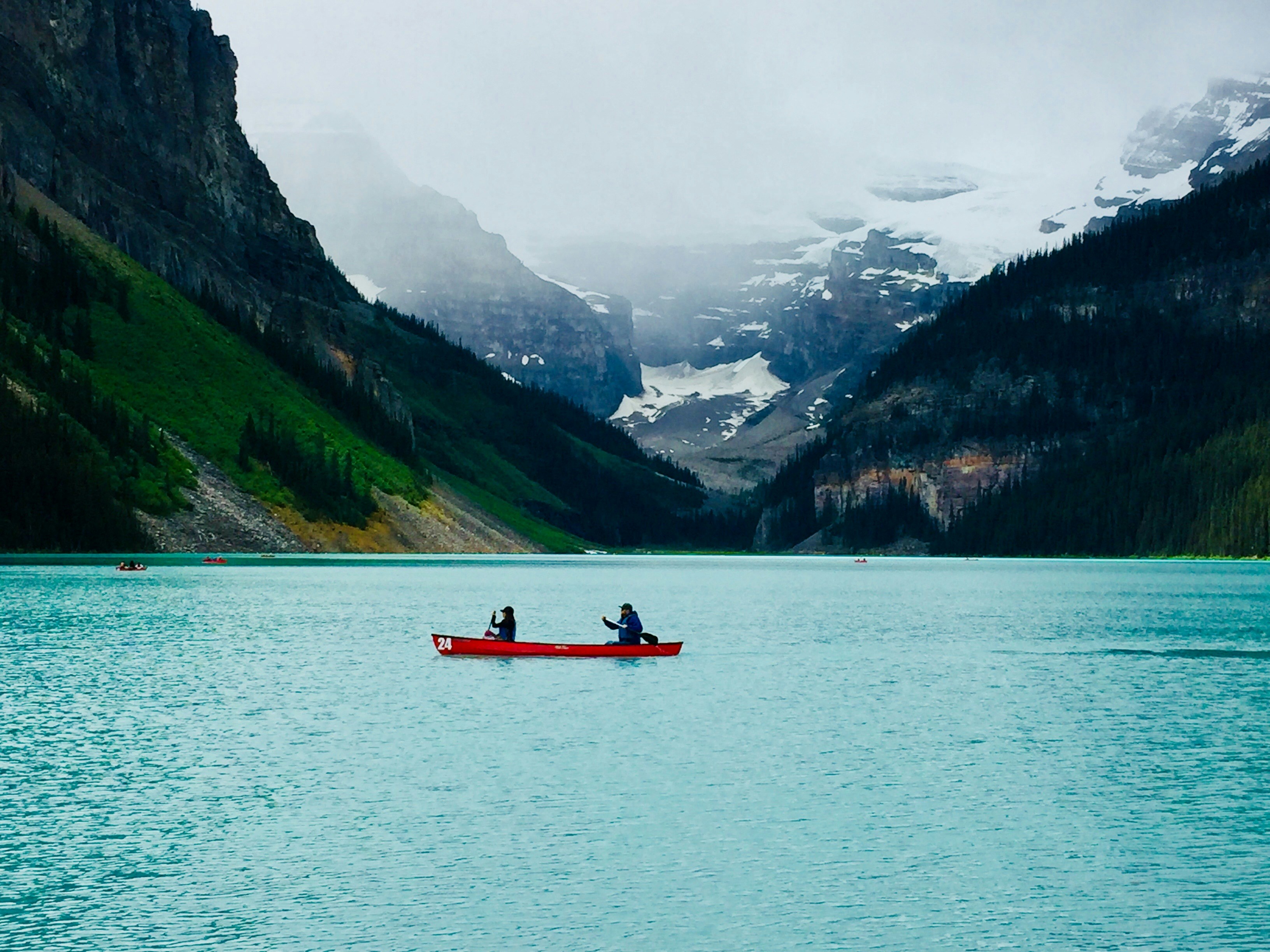 person riding red boat on body of water during daytime