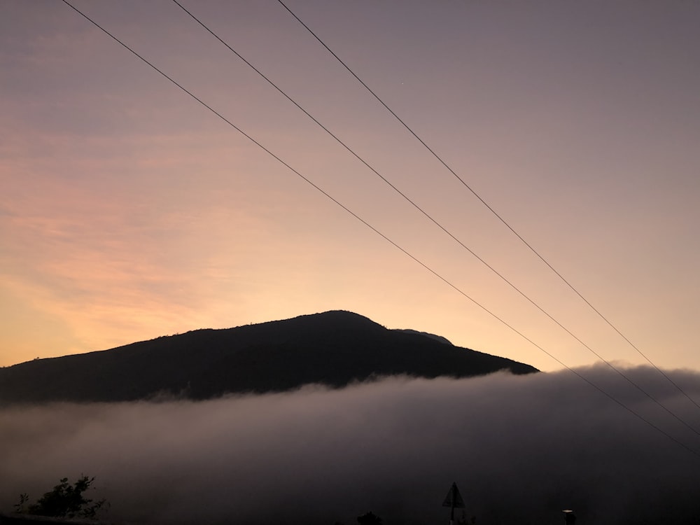 silhueta da montanha sob o céu nublado durante o dia
