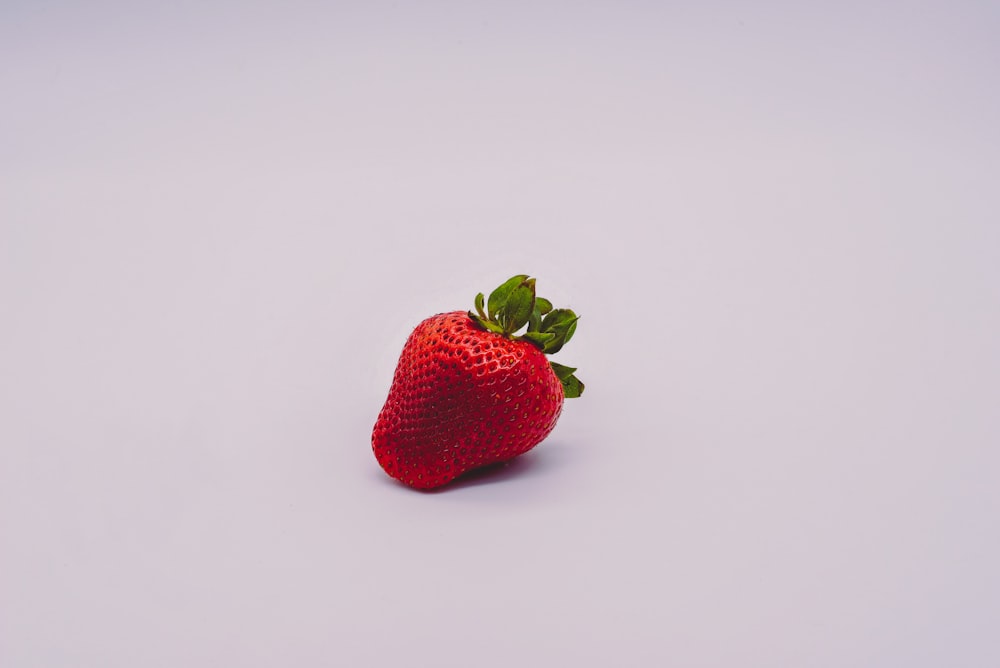 red strawberry on white surface