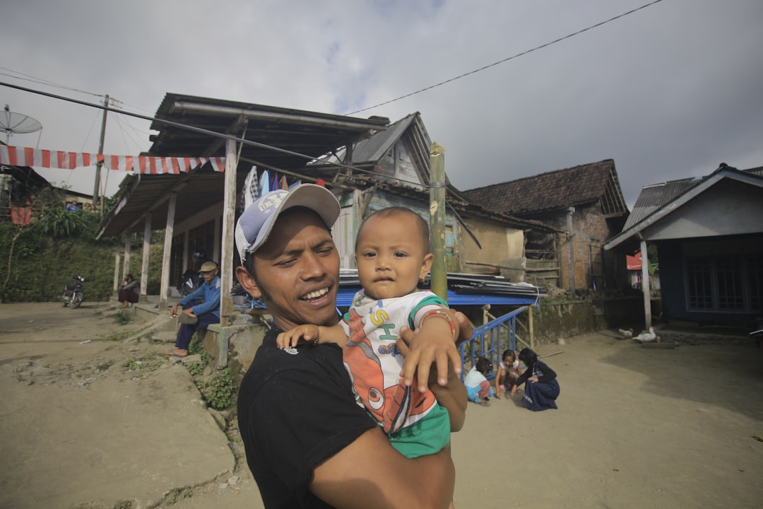 Man with child with a background of house in slums.