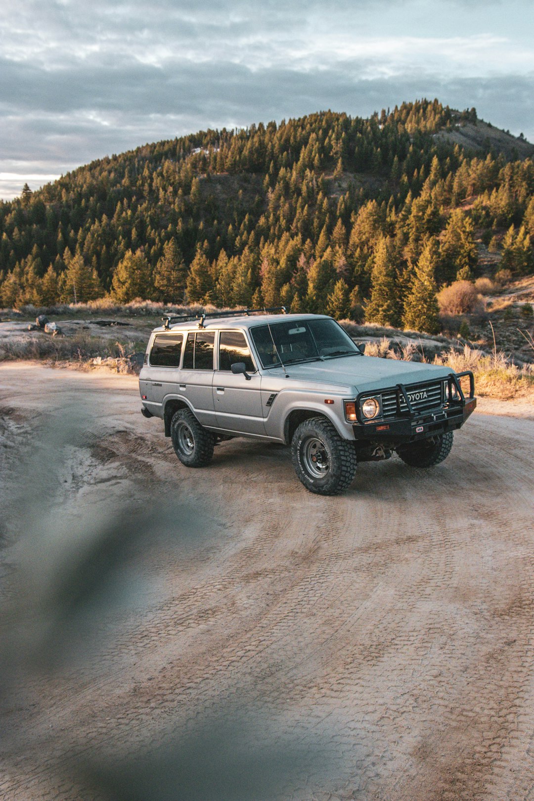 white and black jeep wrangler on dirt road during daytime