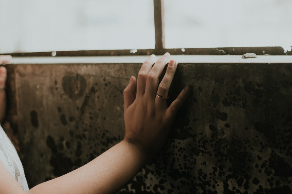 person holding brown and black floral textile