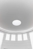 Architectural dome allowing natural light into a spacious living room with minimalist decor.