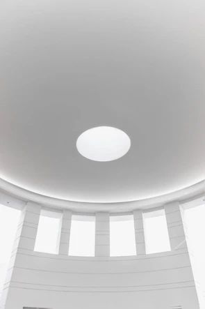 Architectural dome allowing natural light into a spacious living room with minimalist decor.