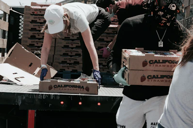 man in white t-shirt and white pants holding black and white box