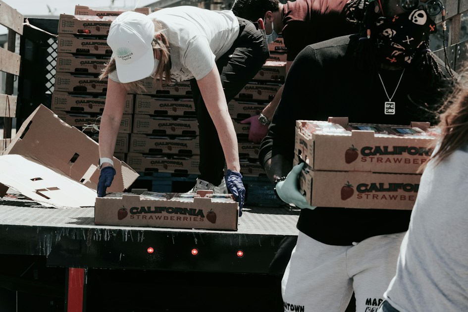 Man in white t-shirt and white pants holding black and white box