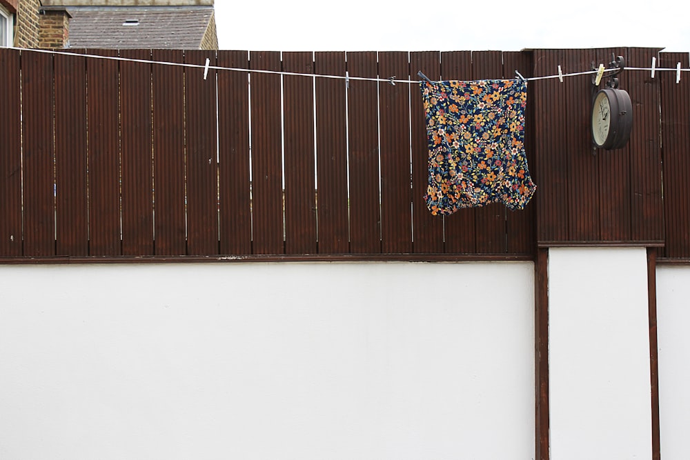 brown wooden wall with white blue and red floral textile