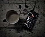A peaceful morning scene with a cup of coffee and a phone displaying nexoria