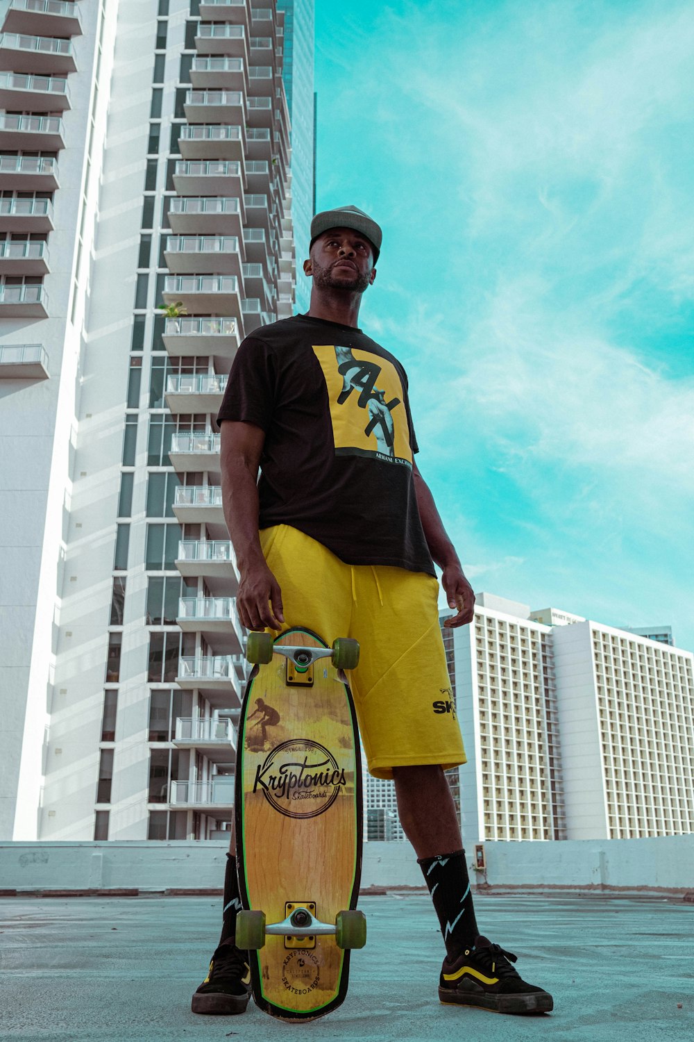 man in black crew neck t-shirt and yellow shorts standing on brown wooden ladder during