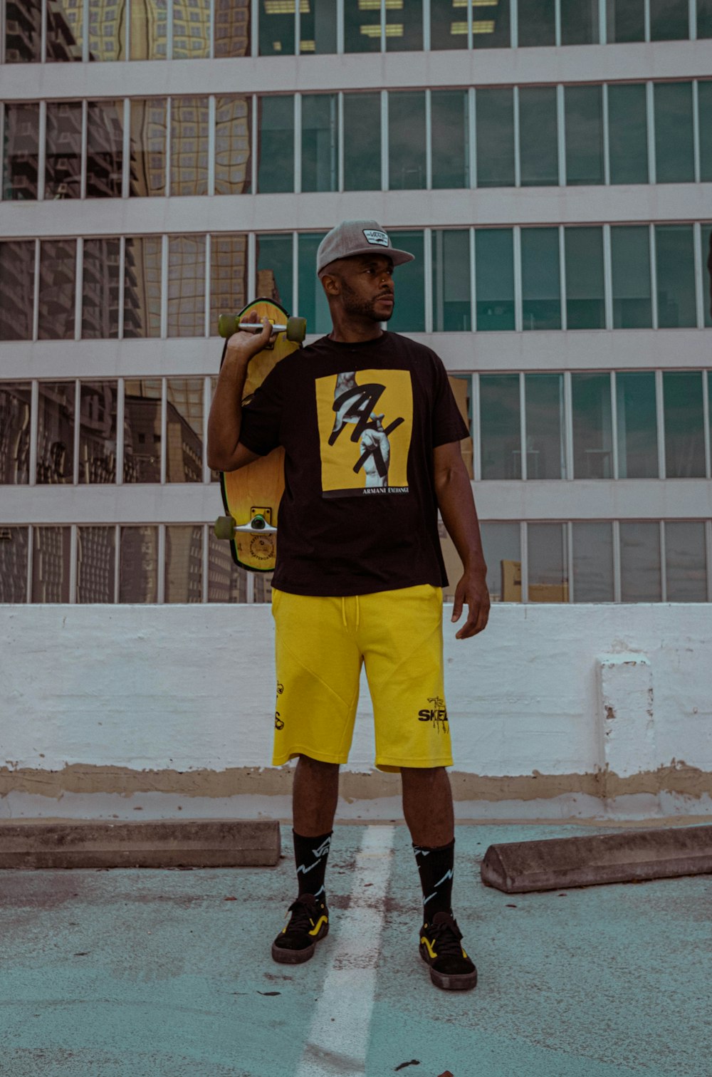 man in black and yellow nike crew neck t-shirt and yellow shorts standing  on brown photo – Free Clothing Image on Unsplash