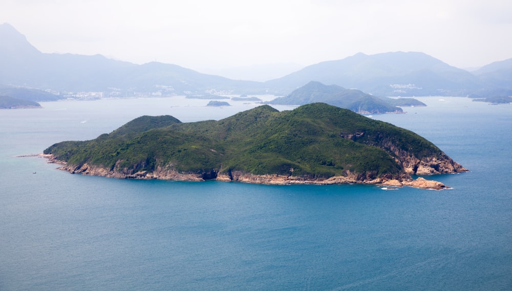 Montañas verdes junto al mar azul durante el día