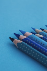 blue and black pencil on teal surface