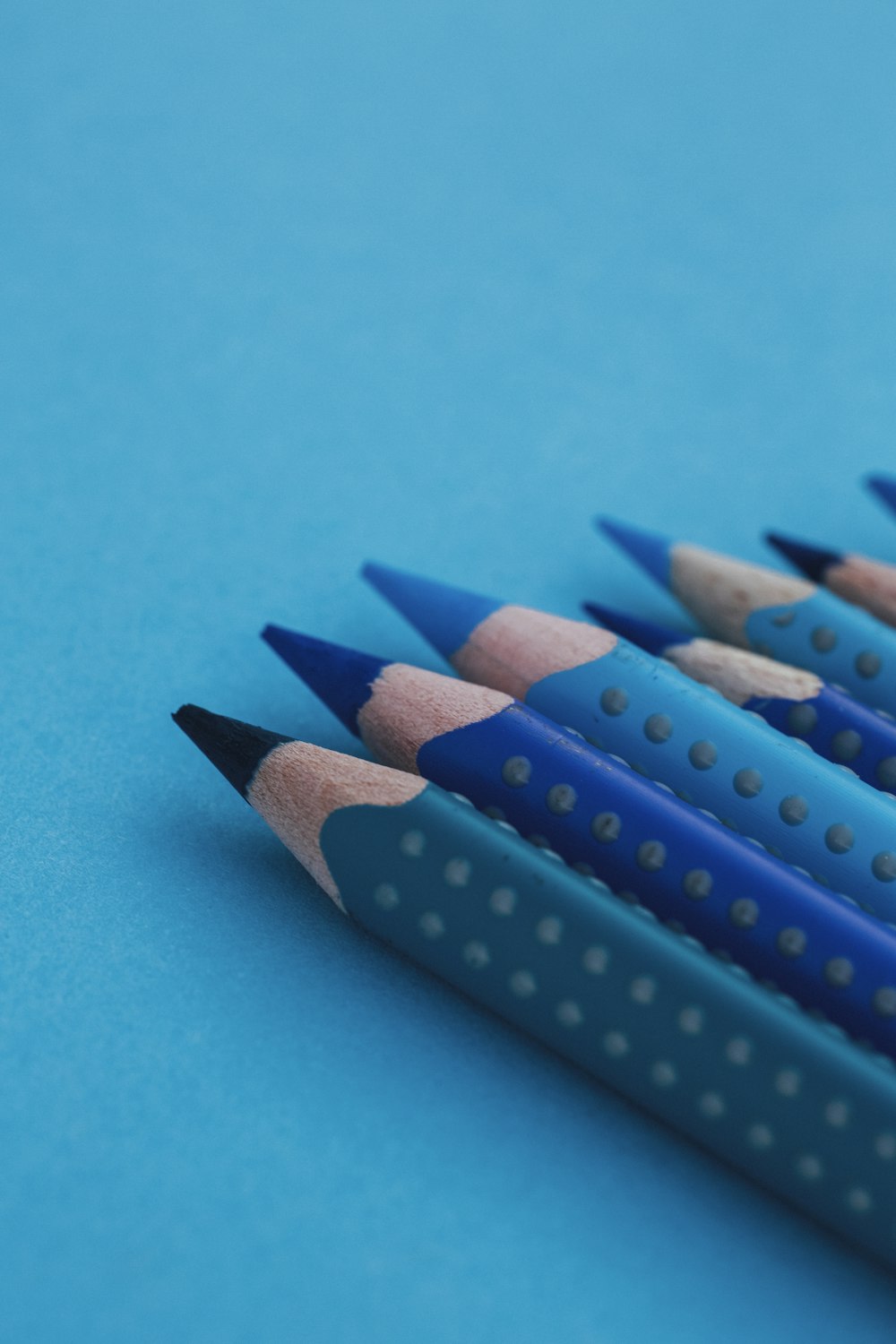 lápis azul e preto na superfície azul-petróleo
