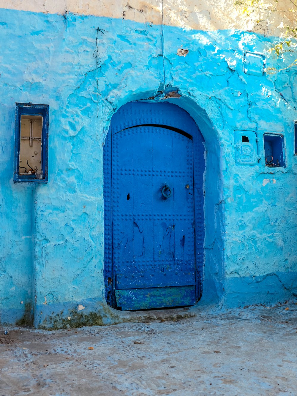 blue wooden door on blue concrete wall