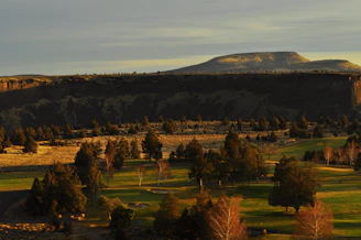 A wide shot of a natural landscape used as a film backdrop at golden hour.