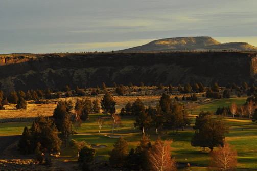 A wide shot of a natural landscape used as a film backdrop at golden hour.