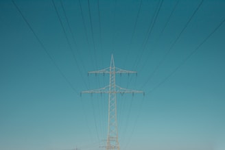 white electric post under blue sky during daytime