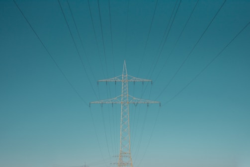 white electric post under blue sky during daytime