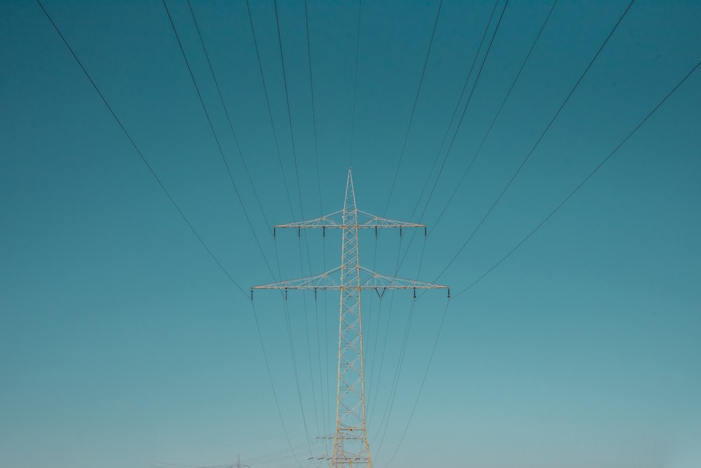 white electric post under blue sky during daytime