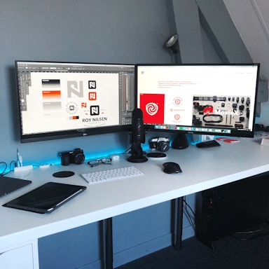 Modern office workspace with blue and white decor and digital devices on desk