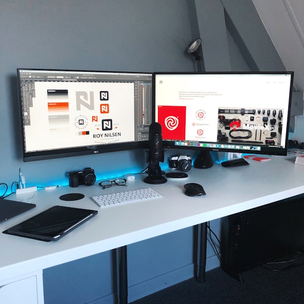 A tidy workspace featuring dual monitors displaying bank reconciliation reports