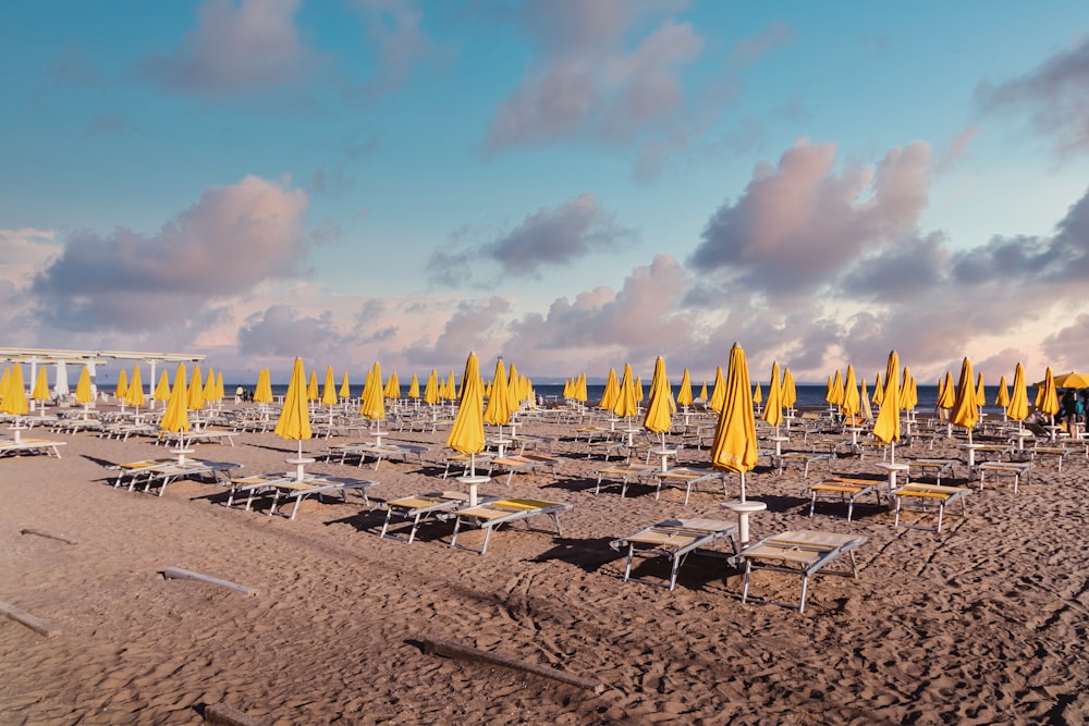 a beach filled with lots of yellow umbrellas