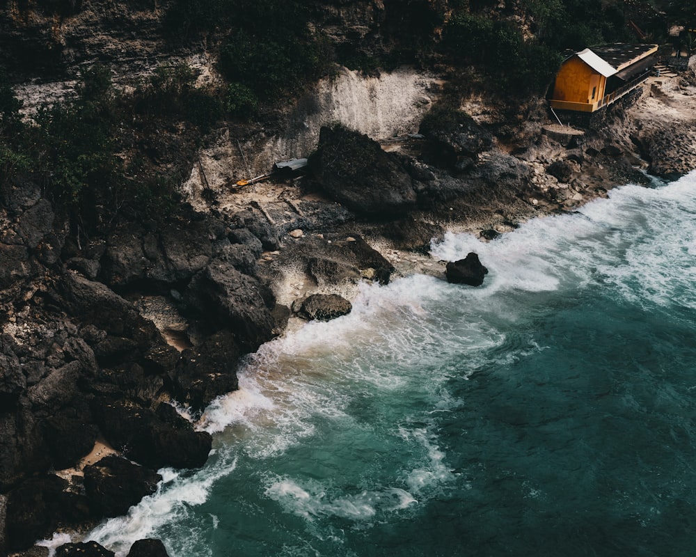 brown and white tent on rocky shore near body of water during daytime