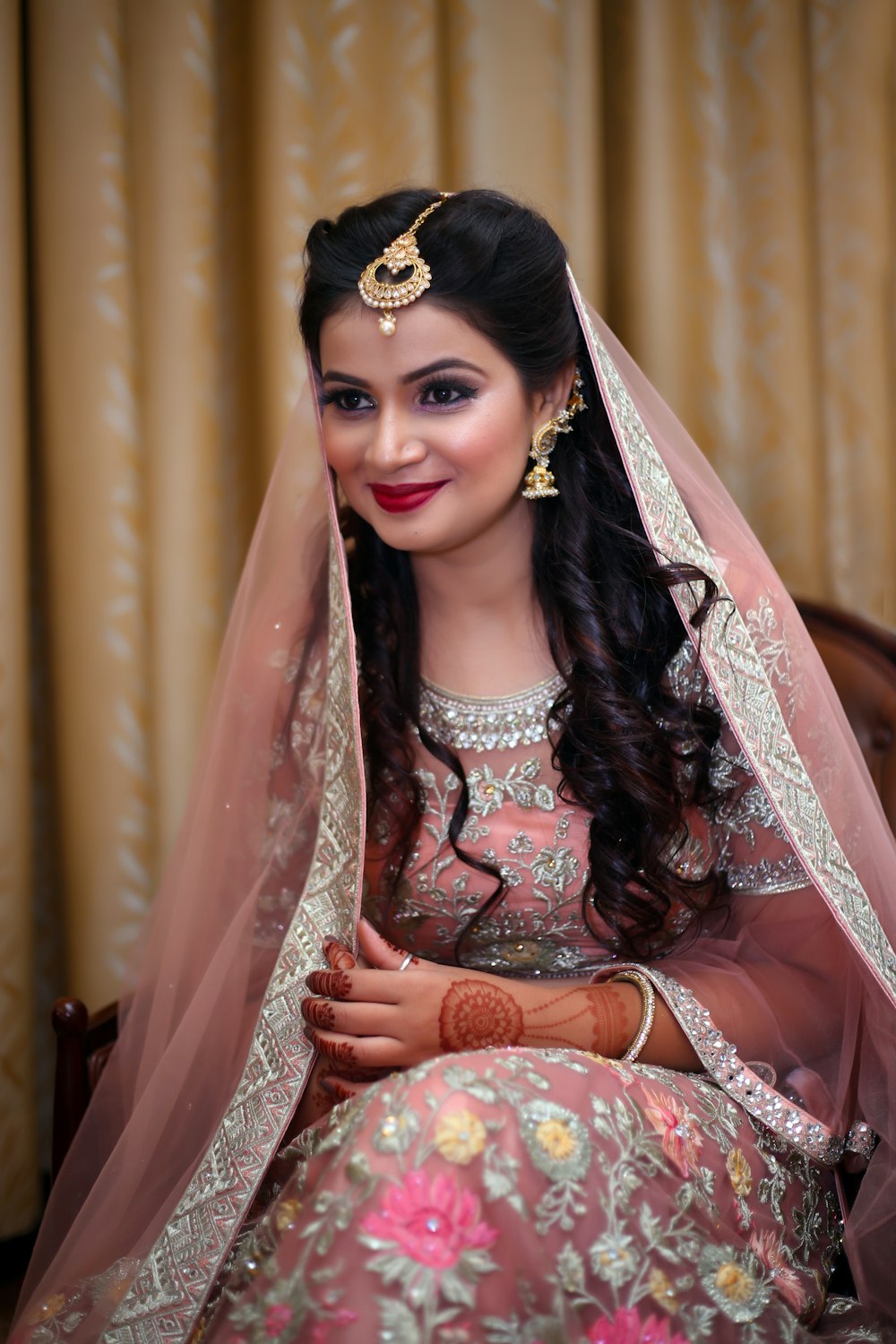 Femme en robe fleurie blanche et rouge portant une couronne d’or