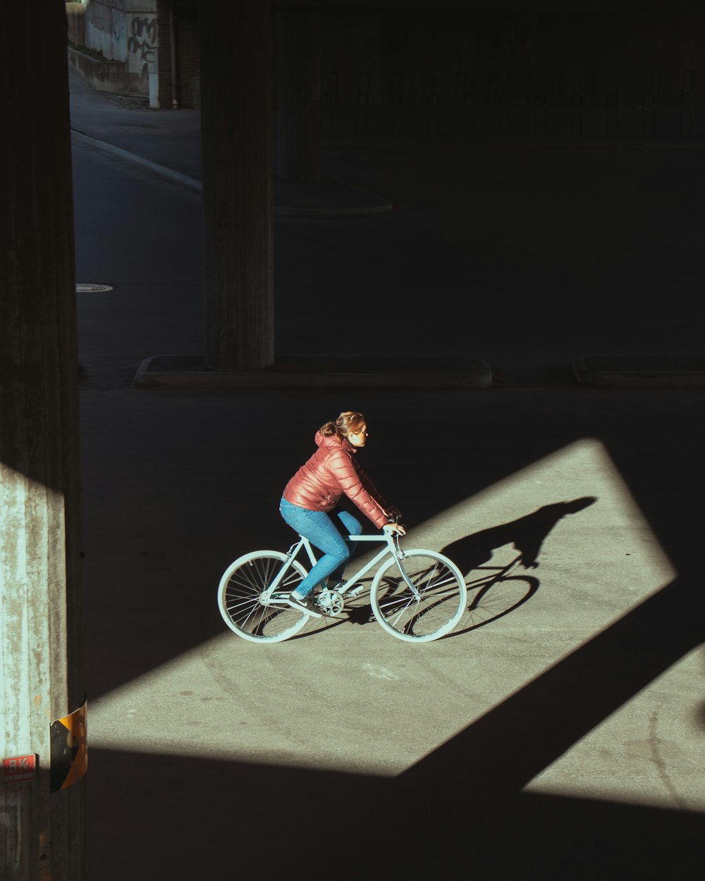 girl in pink shirt riding on blue bicycle